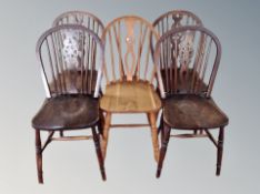 A set of four oak wheel backed dining chairs and one other similar (5)