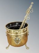 A Victorian brass cylindrical coal receiver on paw feet together with several companion pieces