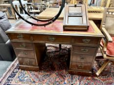 An early 20th century mahogany twin pedestal writing desk fitted with nine drawers,
