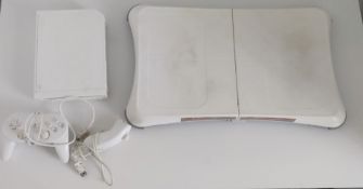 Wii games console with fit board, controllers and a selection of games.