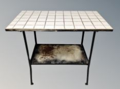A cast iron tiled topped two tier table,