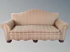 An early 20th century three seater salon settee on carved bulbous feet,