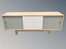 A late 20th century blond oak sliding door low sideboard,