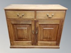 An oak sideboard fitted with cupboards and doors,