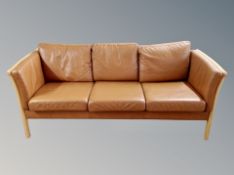 A late 20th century Danish stitched tan leather three seater beech framed settee,
