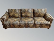 A Danish three seater low settee upholstered in a William Morris style Arts and Crafts fabric,