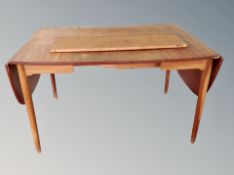 A Danish teak extending drop leaf dining table with two additional leaves,