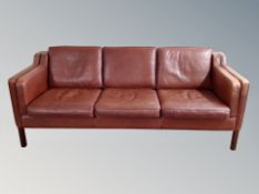 A late 20th century Stouby brown/terracotta leather three seater settee,