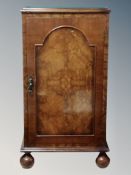 A burr walnut pot cupboard on bun feet with later glass top,