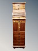 A stained pine roll top slim chest, fitted cupboards and drawers,