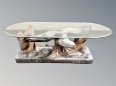 A contemporary glass coffee table on eagle pedestal,