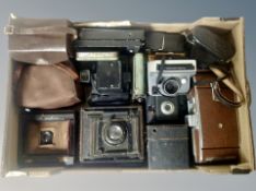 A collection of vintage cameras, two early 20th century bellows cameras, large Polaroid camera,