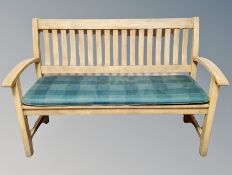 A teak garden bench with cushion,