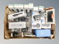 A box of facial skin scrubbers, selfie sticks, echo dot wall mounts, children's headphones,