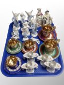 A group of porcelain figures, gilt tea cups and saucers,