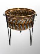 A copper jardiniere on raised legs,