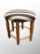 A hexagonal footstool in striped upholstery