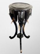 An Indian ebonised jardiniere stand carved with elephant supports,