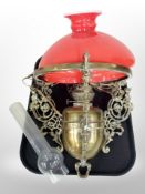 An early 20th century Continental brass hanging oil lamp with red shade