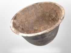 An antique cast iron planter and a manhole cover