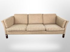 A late 20th century Danish three seater settee in striped oatmeal colour fabric,