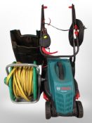 A Bosch electric lawn mower and a hose pipe on reel