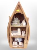 A group of Lilliput Lane ornaments on a wooden shelf in the form of a rowing boat