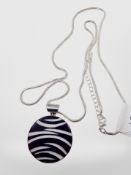 A silver enamel pendant on white metal snake chain