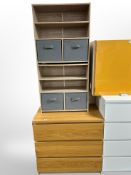 A contemporary oak effect three drawer chest and a further open bookcase with storage baskets