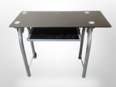 A contemporary black glass and metal computer table,