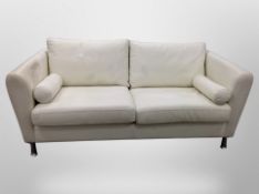 A contemporary cream leather two seater settee on metal legs with bolster cushions,