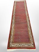 A machine made runner of Persian design,