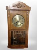 An oak eight day wall clock with brass dial