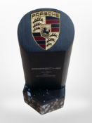 A Porsche paperweight on faux marble box/plinth,