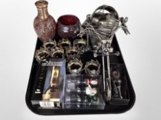 A metal bottle holder in the form of a motorbike together with a set of metal napkin rings,