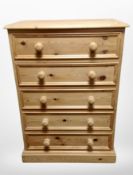 A contemporary pine five drawer chest,