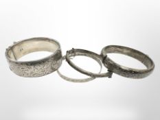 A good quality engraved silver bangle, London 1963, together with three further silver bangles.