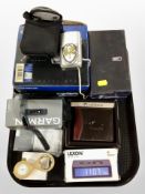 An Olympus digital camera together with Garmin sport's watch, digital alarm clock,