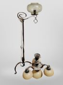 A Scandinavian wrought metal standard lamp and a further pendant light fitting with opaque glass