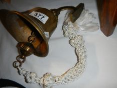A wall mounting brass bell.