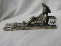 A metal figure of an oriental fisher man.