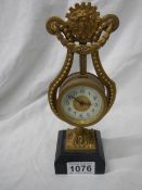 A brass lyre shaped mantel clock on slate base, a/f.