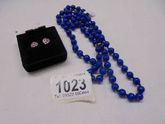 An old blue stone necklace and a pair of gold multistone ear studs.