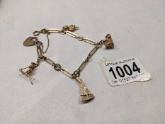 A 9ct gold charm bracelet with four gold charms and padlock, 18.5 grams.