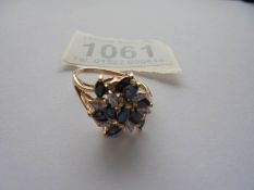 A sapphire and diamond cluster ring, marquise cut sapphires in 9ct gold size O.