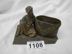 A mid Victorian figure of an Indian gentleman sitting on a carpet(poss a pin cushion but no cushion)