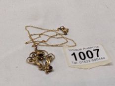 A 9ct gold Edwardian pendant on a fine yellow metal chain.