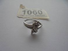 A diamond twist ring in 9ct white gold with diamond set shoulders, size K half.