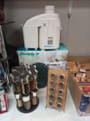 A 12 piece spice rack, a 10 piece spice rack, cast metal hot plate stand and The Juicelady Jr