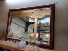 A dark wood framed bevel edge mirror